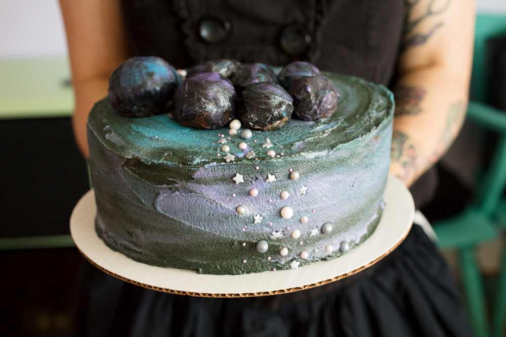 vegan chocolate cake with galaxy buttercream frosting and cookie dough asteroids on top