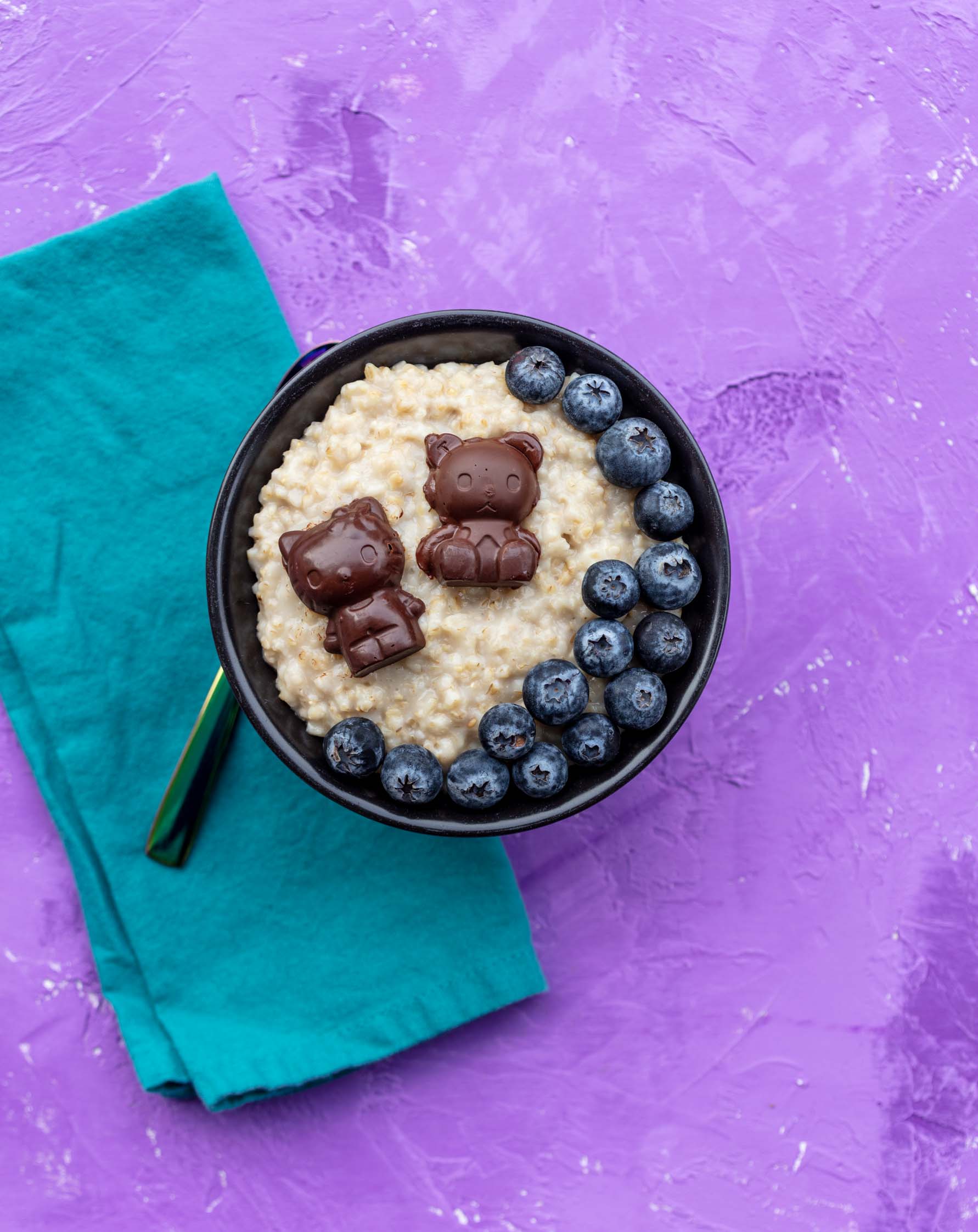 bowl of steel cut oatmeal with hello kitty chocolates and blueberries