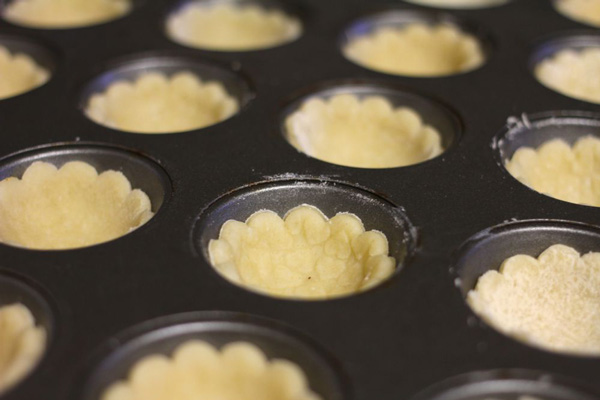 mini muffin pan filled with vegan cookie pie crust